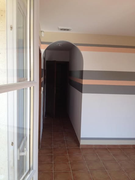 Interior with decorative painted stripes and arched doorway